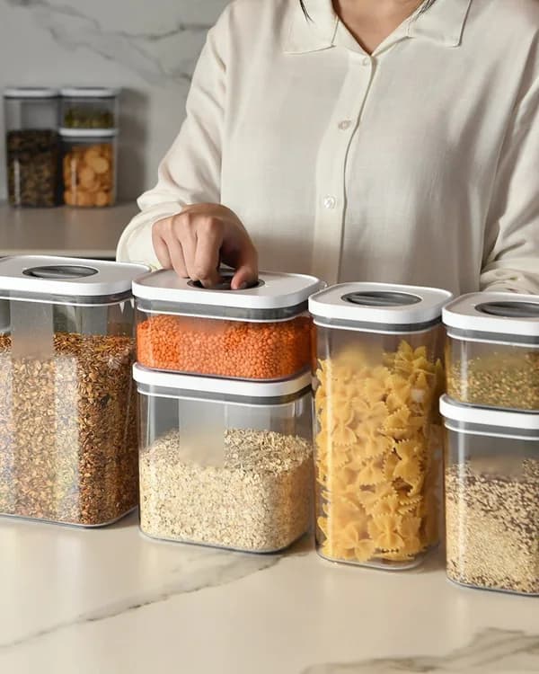 Potes herméticos com grãos sobre a bancada de uma cozinha