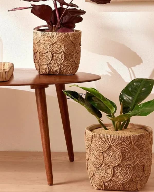 Mesa lateral de madeira com vasos de cimento e plantas numa sala
